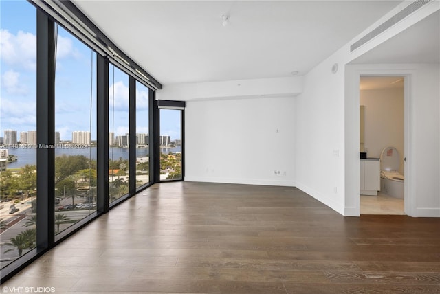 spare room with dark wood-type flooring and a water view