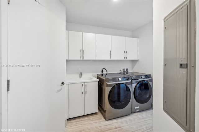 washroom featuring separate washer and dryer, light hardwood / wood-style floors, cabinets, and sink