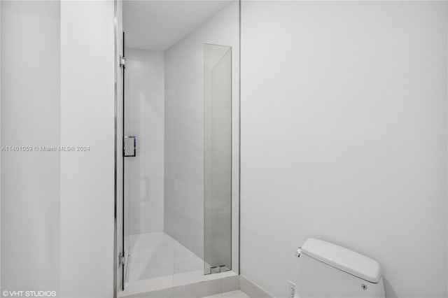 bathroom featuring toilet and tiled shower