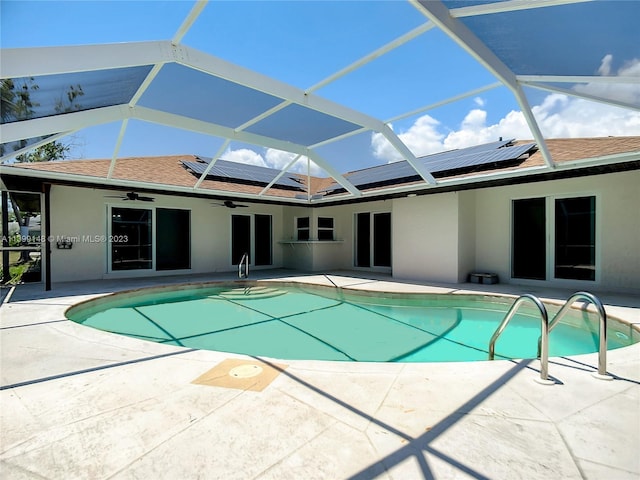 view of swimming pool with glass enclosure and a patio