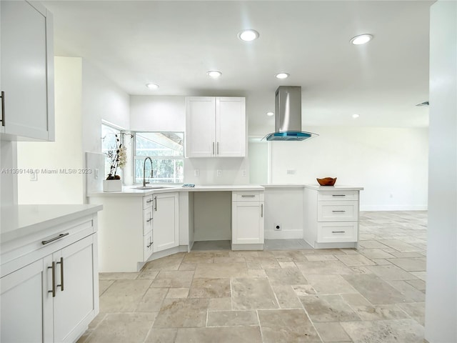 kitchen with light tile floors, white cabinetry, sink, and island exhaust hood