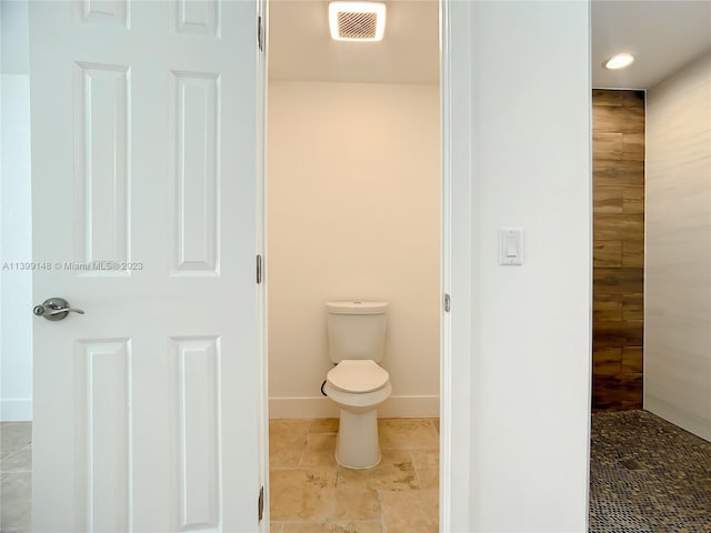 bathroom featuring tile flooring and toilet