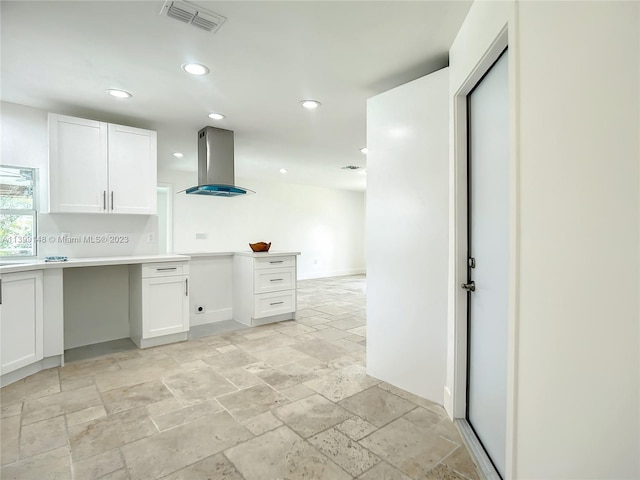 kitchen featuring white cabinets, light tile flooring, and island exhaust hood