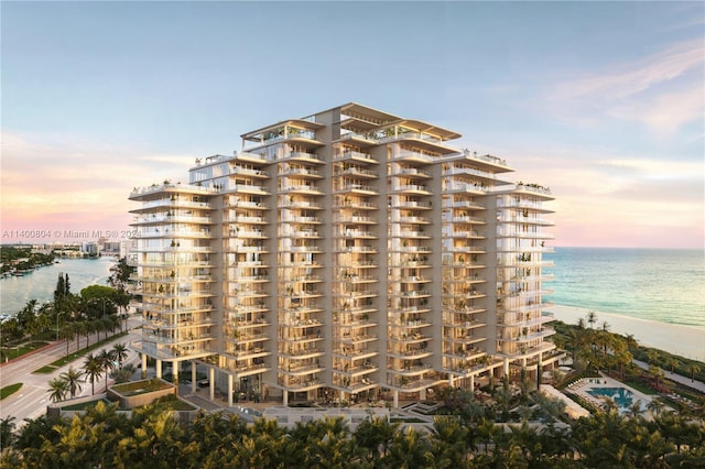 outdoor building at dusk featuring a beach view and a water view