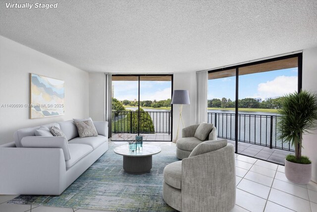 tiled living room with a water view and a textured ceiling