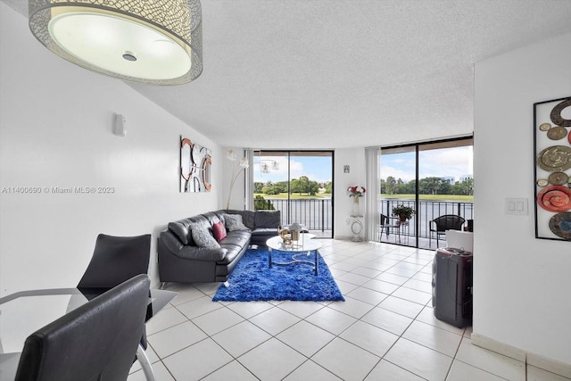 living room featuring expansive windows, light tile floors, and a textured ceiling