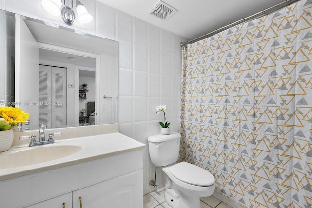 bathroom with tile walls, tile floors, toilet, and vanity