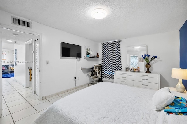 tiled bedroom featuring a textured ceiling