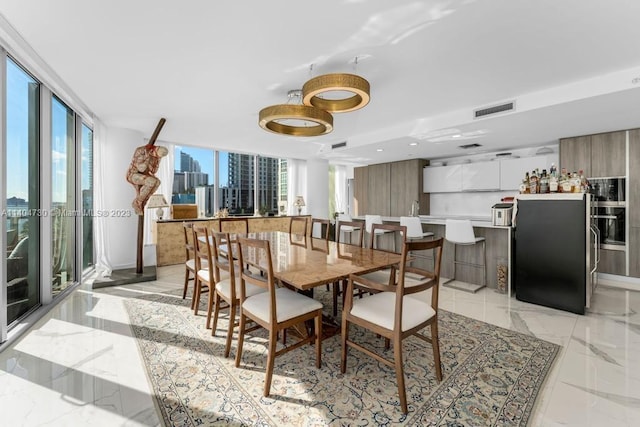 tiled dining area with floor to ceiling windows