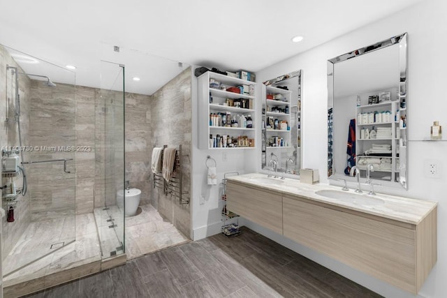 bathroom featuring a bidet, double sink, an enclosed shower, and large vanity