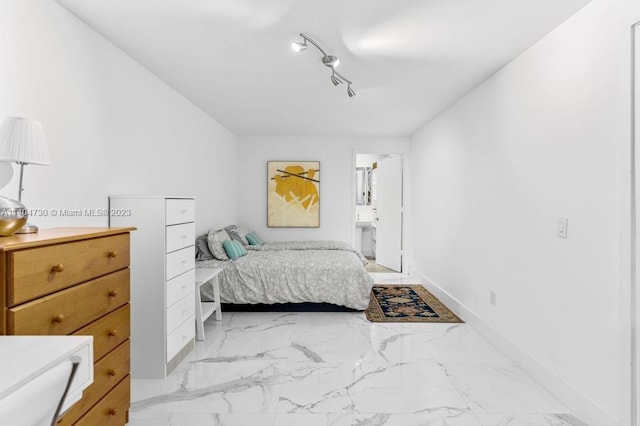 bedroom with track lighting, light tile flooring, and connected bathroom