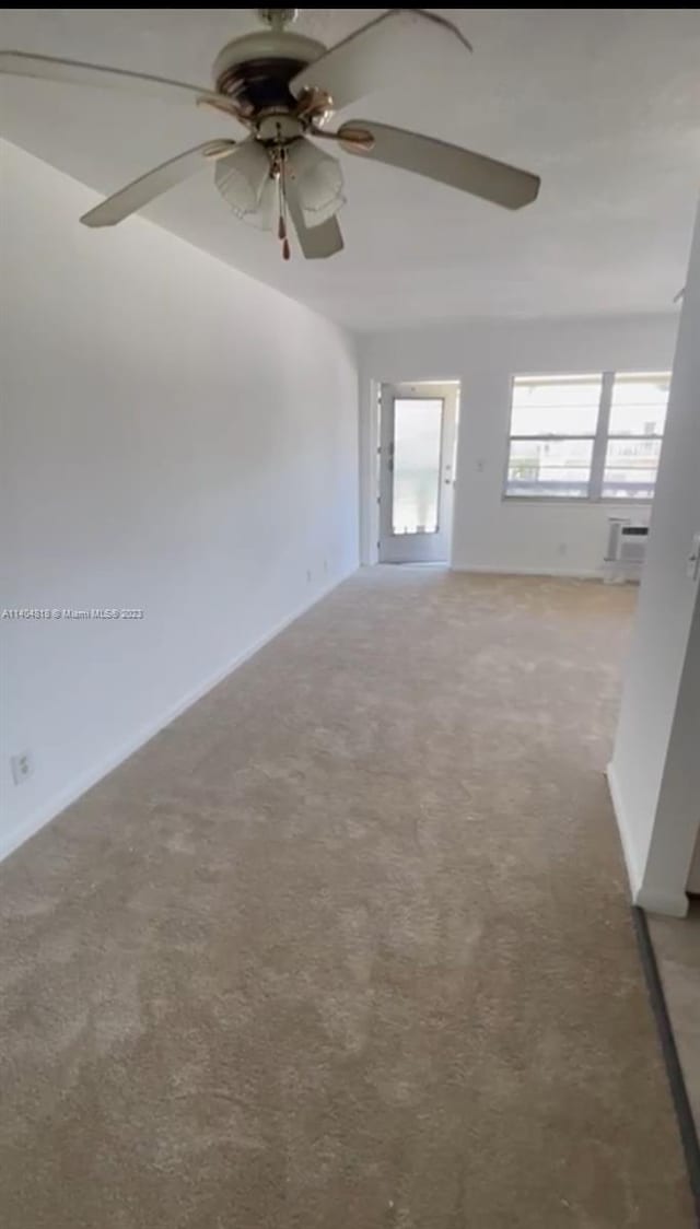 carpeted spare room featuring ceiling fan