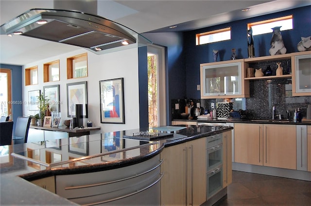 kitchen featuring sink, dark tile patterned flooring, a wealth of natural light, backsplash, and island exhaust hood