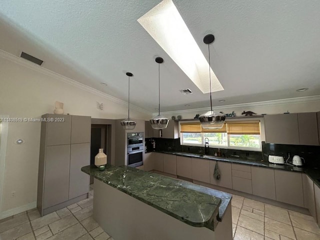 kitchen featuring stainless steel double oven, pendant lighting, ornamental molding, and dark stone countertops