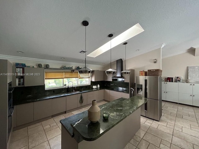 kitchen with pendant lighting, light tile floors, stainless steel fridge with ice dispenser, a skylight, and wall chimney exhaust hood