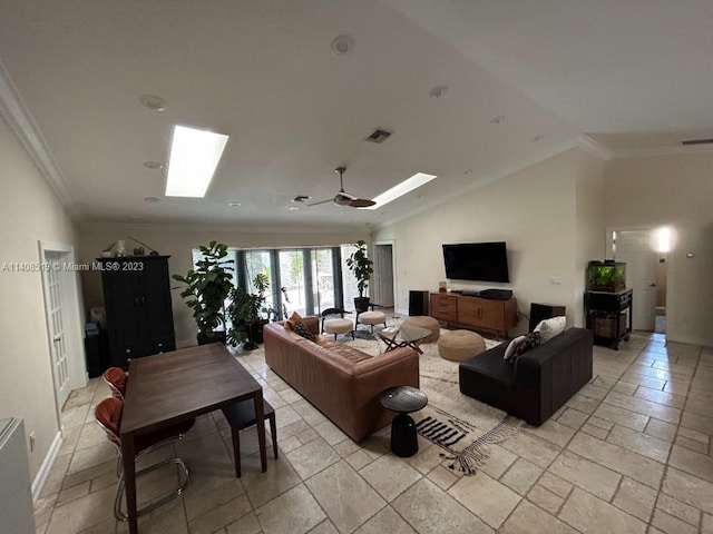 tiled living room featuring ornamental molding, vaulted ceiling with skylight, and ceiling fan