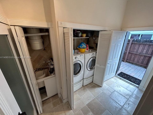 clothes washing area with light tile flooring and washing machine and clothes dryer