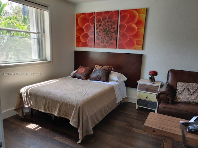 bedroom with dark hardwood / wood-style flooring