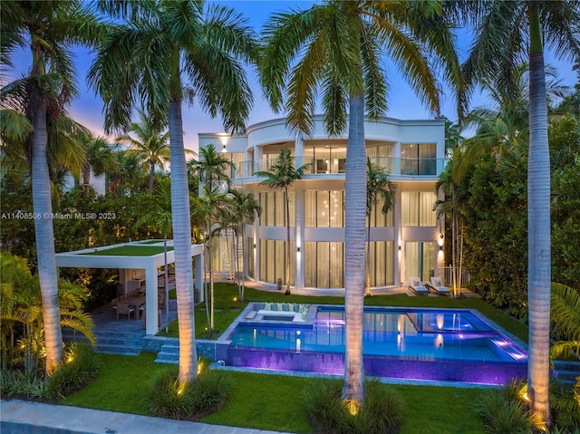 exterior space featuring a balcony, a patio area, and a lawn