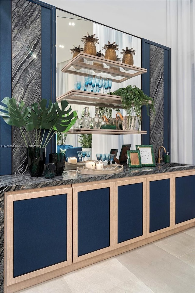 bar featuring light tile flooring and blue cabinets