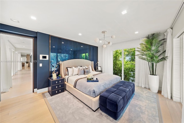 bedroom with a notable chandelier and light wood-type flooring