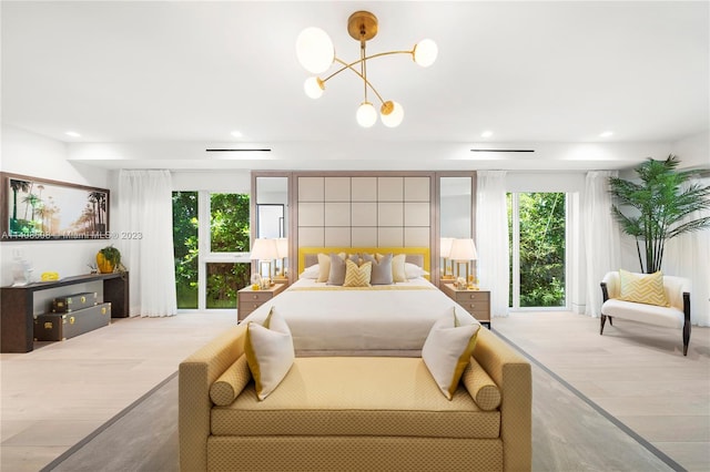 bedroom with light hardwood / wood-style floors and an inviting chandelier