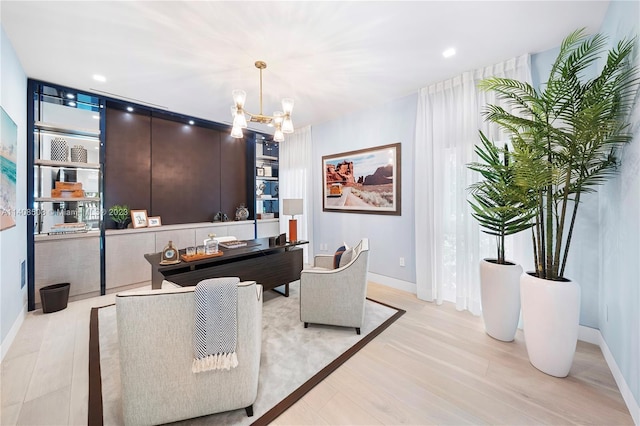 living room featuring an inviting chandelier and light wood-type flooring