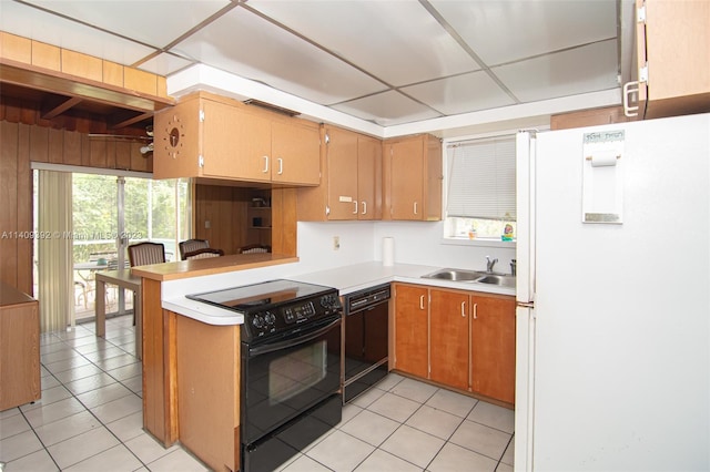 kitchen featuring light tile flooring, kitchen peninsula, black appliances, and sink