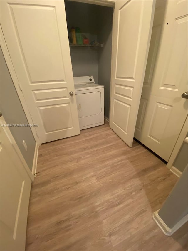 laundry area with light wood-type flooring and washer / dryer