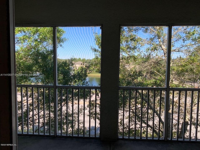 unfurnished sunroom featuring a water view