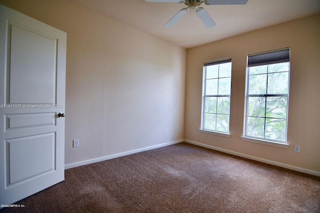 empty room featuring ceiling fan and dark carpet