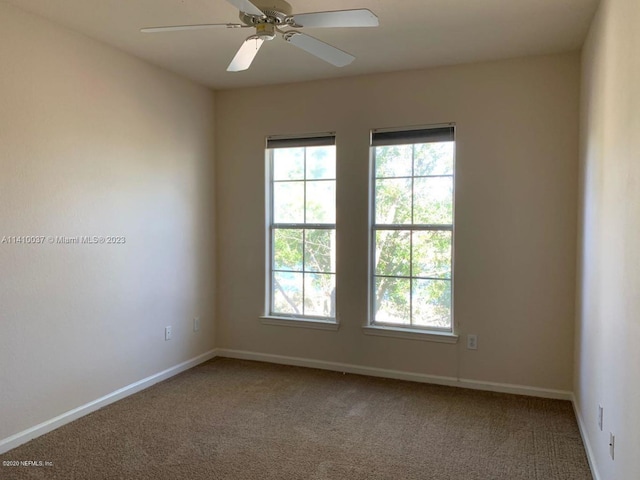 carpeted spare room featuring ceiling fan