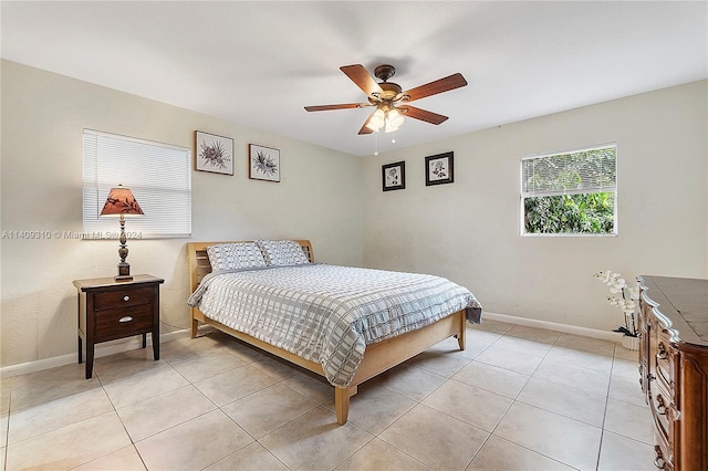 bedroom featuring a ceiling fan, baseboards, and light tile patterned floors