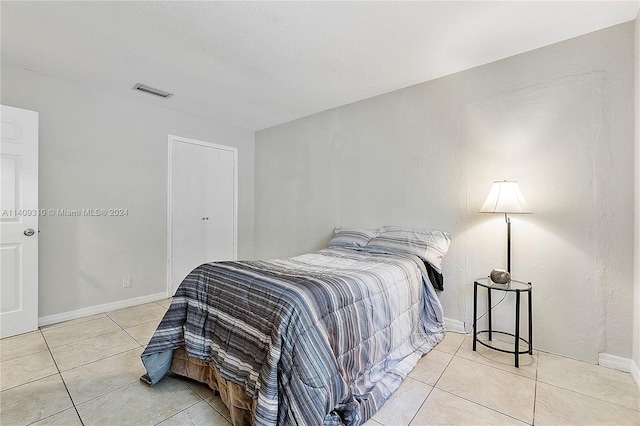 bedroom with light tile patterned floors, visible vents, and baseboards