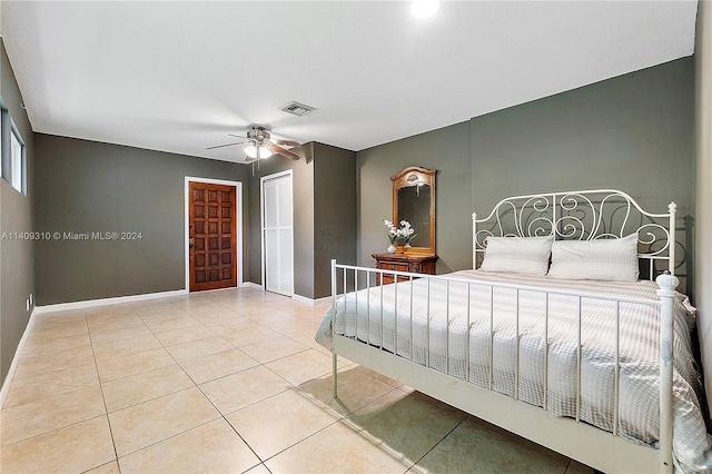 bedroom featuring tile patterned flooring, visible vents, ceiling fan, and baseboards