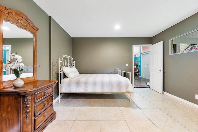 bedroom featuring light tile patterned flooring and baseboards