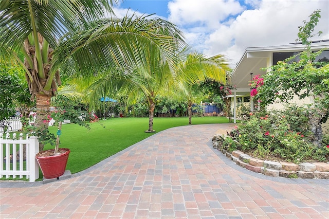 view of community featuring a yard and fence