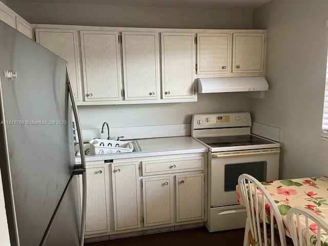 kitchen with stainless steel fridge, sink, and white range with electric stovetop