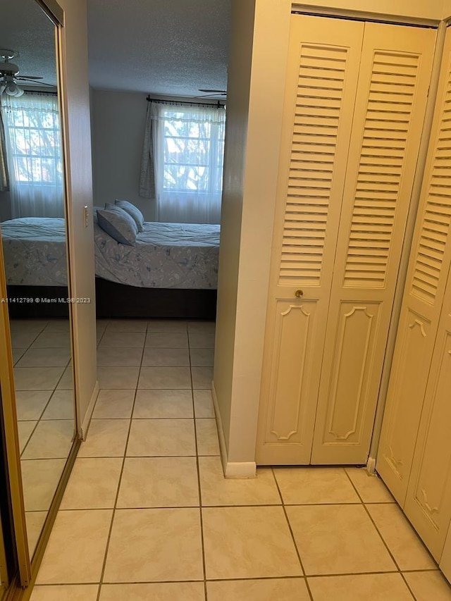 unfurnished bedroom featuring light tile floors, a textured ceiling, and a closet