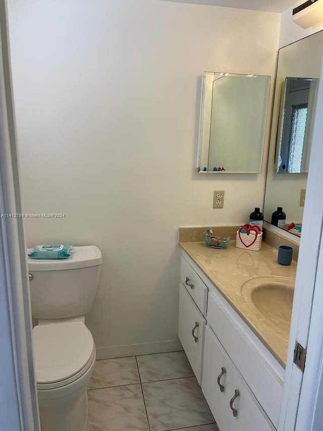 bathroom featuring toilet, tile floors, and oversized vanity