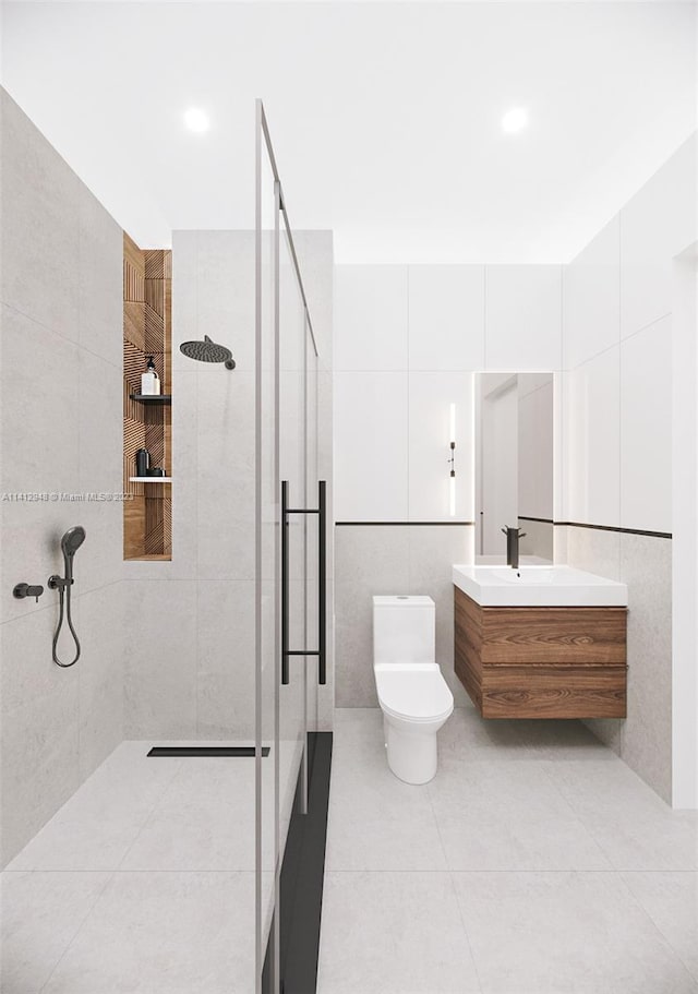 bathroom with tile walls, toilet, an enclosed shower, tile floors, and vanity