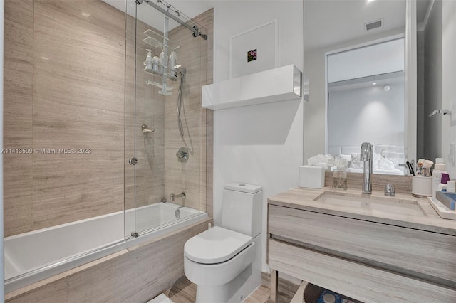 full bathroom with toilet, oversized vanity, and bath / shower combo with glass door