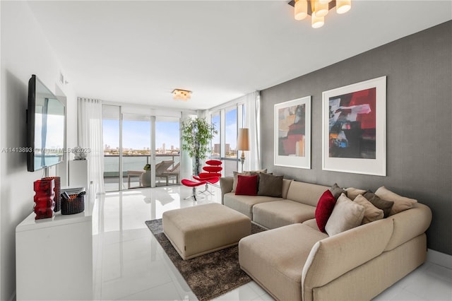 tiled living room featuring a water view and a wall of windows