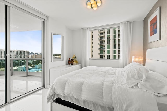 bedroom featuring a wall of windows, light tile flooring, and access to outside