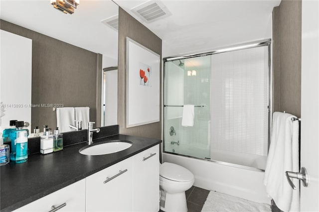 full bathroom featuring enclosed tub / shower combo, toilet, large vanity, and tile floors