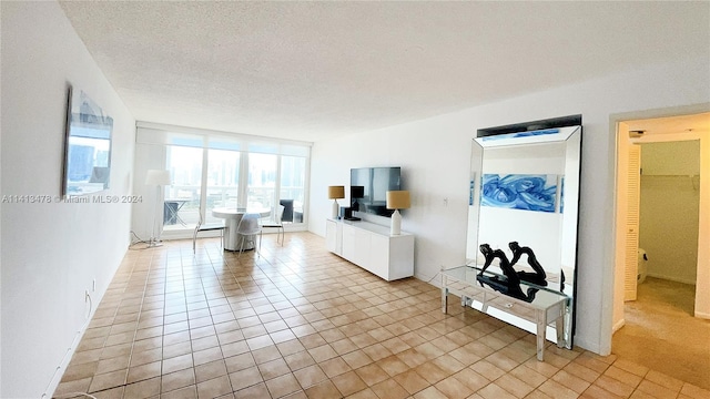 unfurnished living room with a textured ceiling and light tile floors