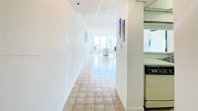 corridor featuring sink and light tile floors