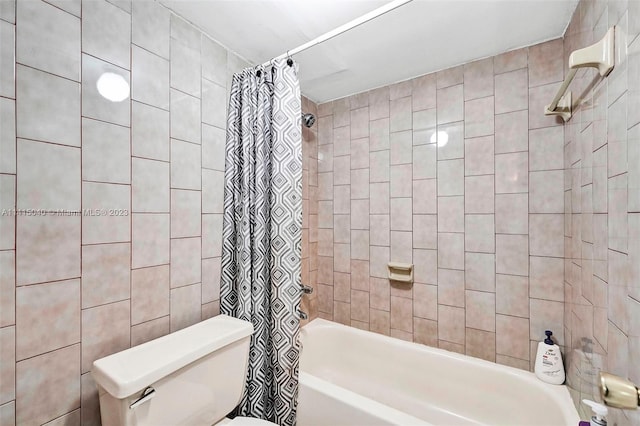 bathroom with shower / tub combo, toilet, and tile walls