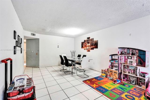 playroom featuring light tile floors and a textured ceiling