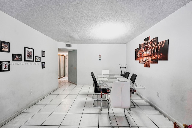 dining area featuring light tile floors and a textured ceiling